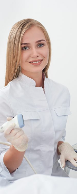 Portrait of beautiful and smiling blonde woman holding ultrasonography equipment in hand, wearing in rubber gloves, with coupling gel prepare for scanning. Special technology button for sonogram.